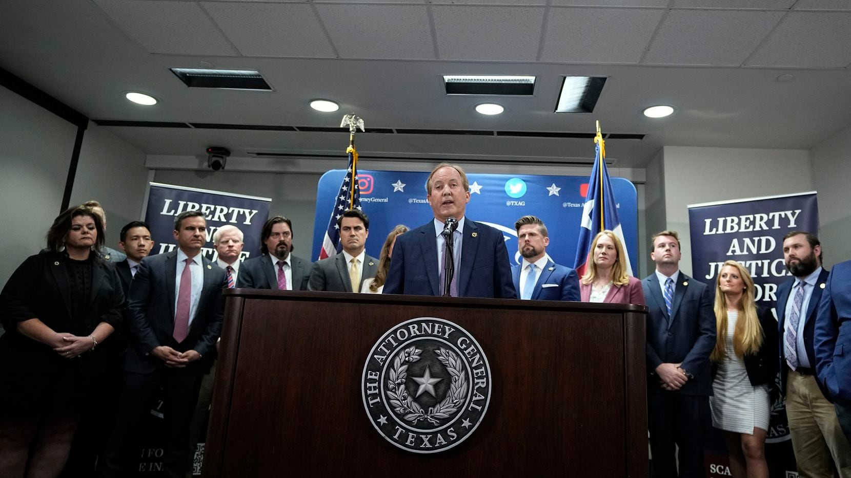 Texas state Attorney General Ken Paxton, center, flanked by his staff, makes a statement at...