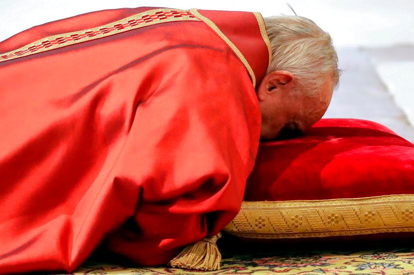 El papa Francisco se postra en oración durante la misal del Viernes Santo en la Basílica de...