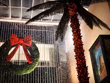 Artificial snow falls along a pathway of palm trees during a demonstration at Galleria Dallas.