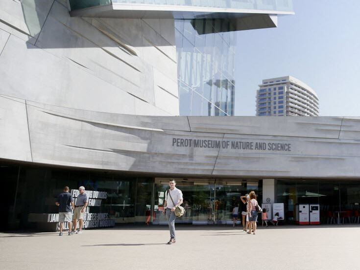 Visitors pose for a photographer in the plaza during the Discovery Days program at the Perot...