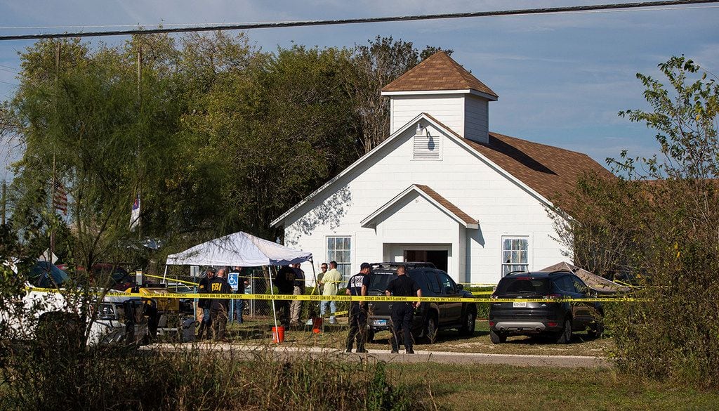 Law enforcement officials work at the scene of a fatal shooting at First Baptist Church in...