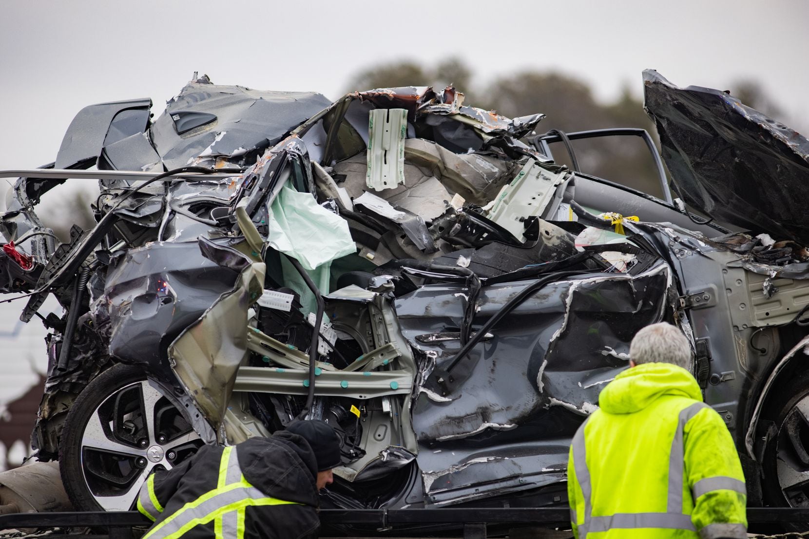 A crumbled car is towed as emergency crews work to clear the mass casualty pile-up on I-35W and Northside Drive in Fort Worth on Thursday, Feb. 11, 2021. (Juan Figueroa/ The Dallas Morning News)