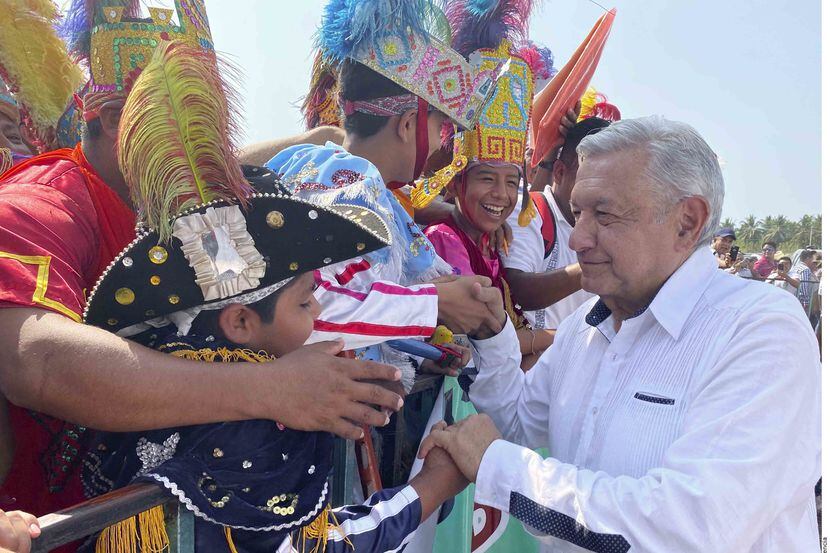 El presidente de México Andrés Manuel López Obrador saluda a personas que asistieron a un...