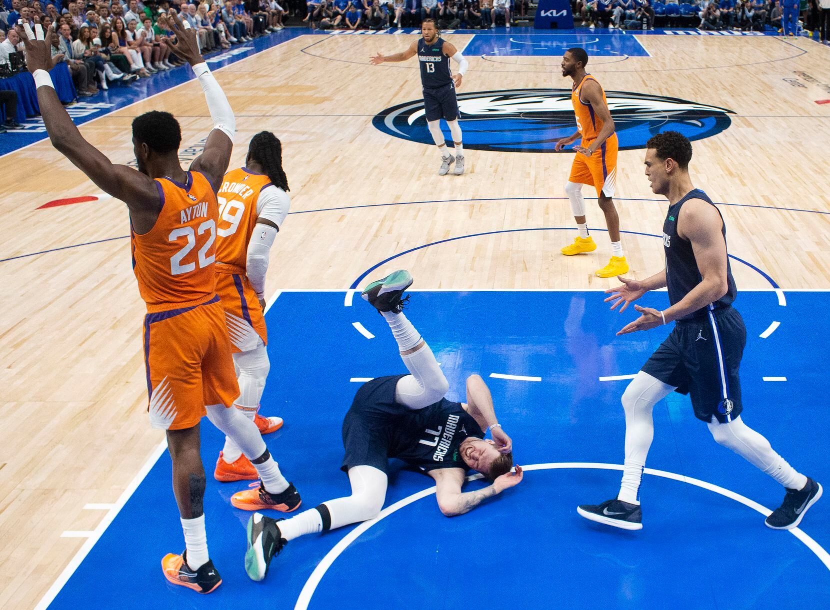 Dallas Mavericks guard Luka Doncic (77) goes down hard in the lane after battling with...
