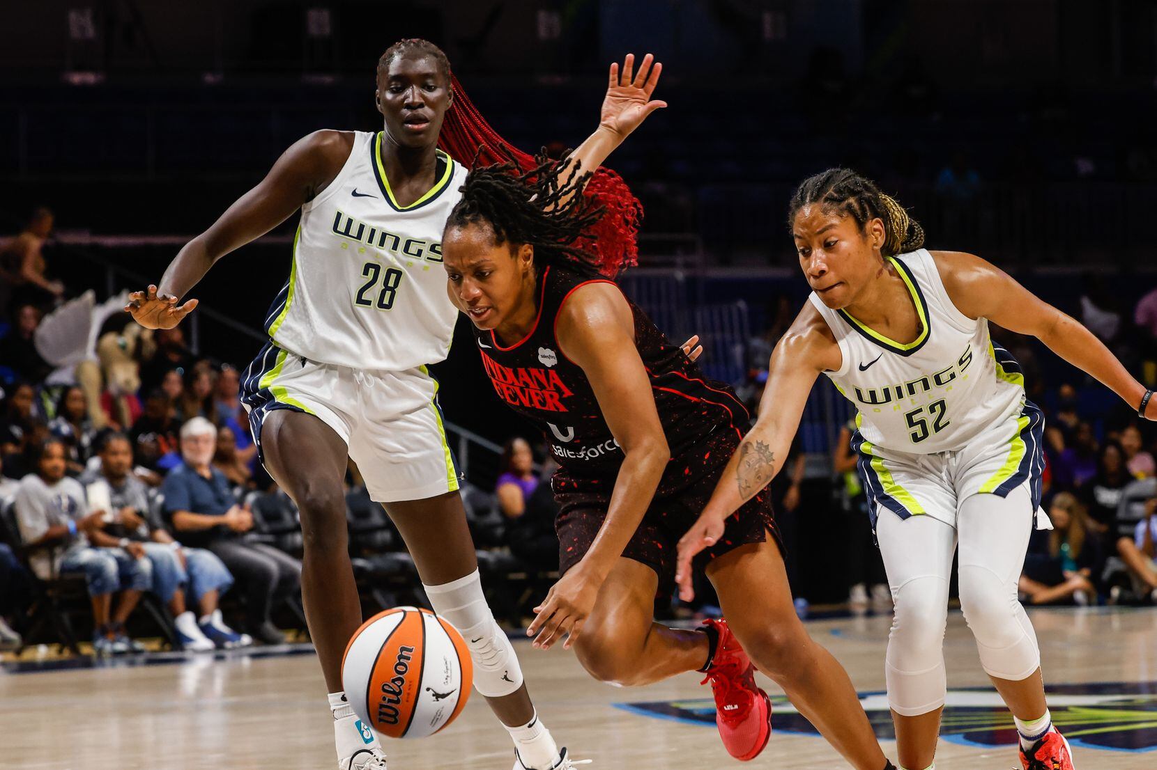Indiana Fever guard Kelsey Mitchell (0) tries to pass between Dallas Wings center Awak Kuier...