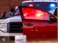 Bullet holes are seen in the door of a sedan after a Dallas police officer and murder...