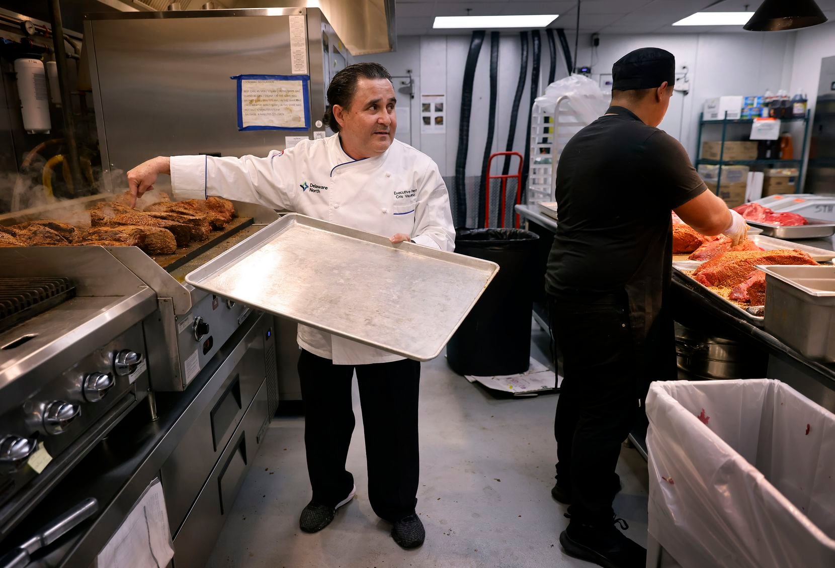 Cris Vázquez (left), executive chef of the Texas Rangers, works to get his kitchens ready...