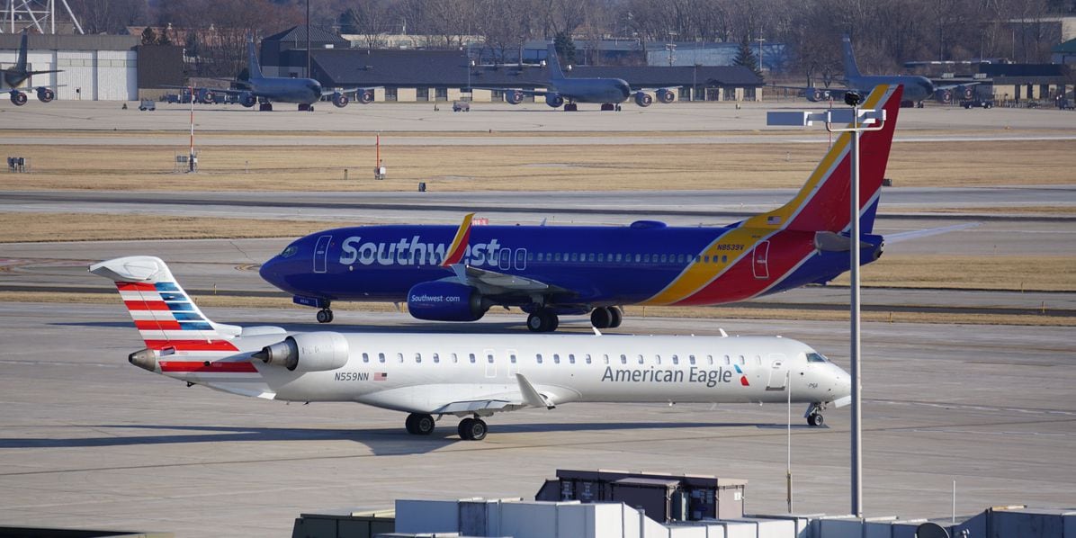A Southwest Airlines Boeing 737 and an American Eagle Bombardier CRJ pass each other on the...