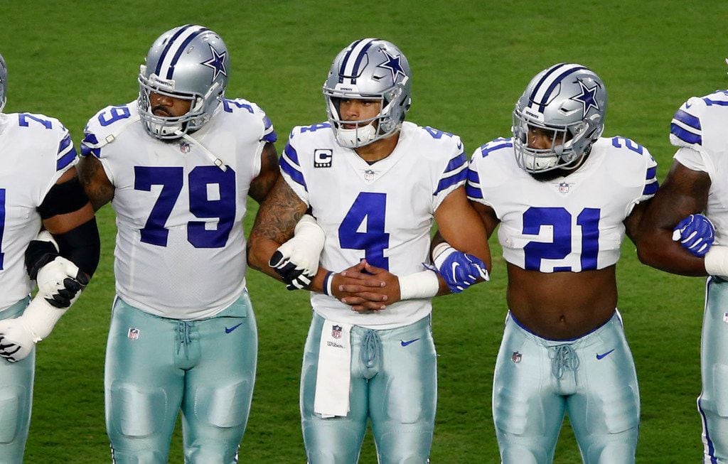 Dallas Cowboys offensive guard Chaz Green (79), Dallas Cowboys quarterback Dak Prescott (4), and Dallas Cowboys running back Ezekiel Elliott (21) and teammates link arms prior to taking a knee before the singing of the National Anthem prior to the start of a game against the Arizona Cardinals at University of Phoenix Stadium in Glendale, Arizona on Monday, September 25, 2017. (Vernon Bryant/The Dallas Morning News)