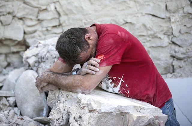 Un hombre llora sobre los escombros de edificios derribados por un poderoso sismo en...