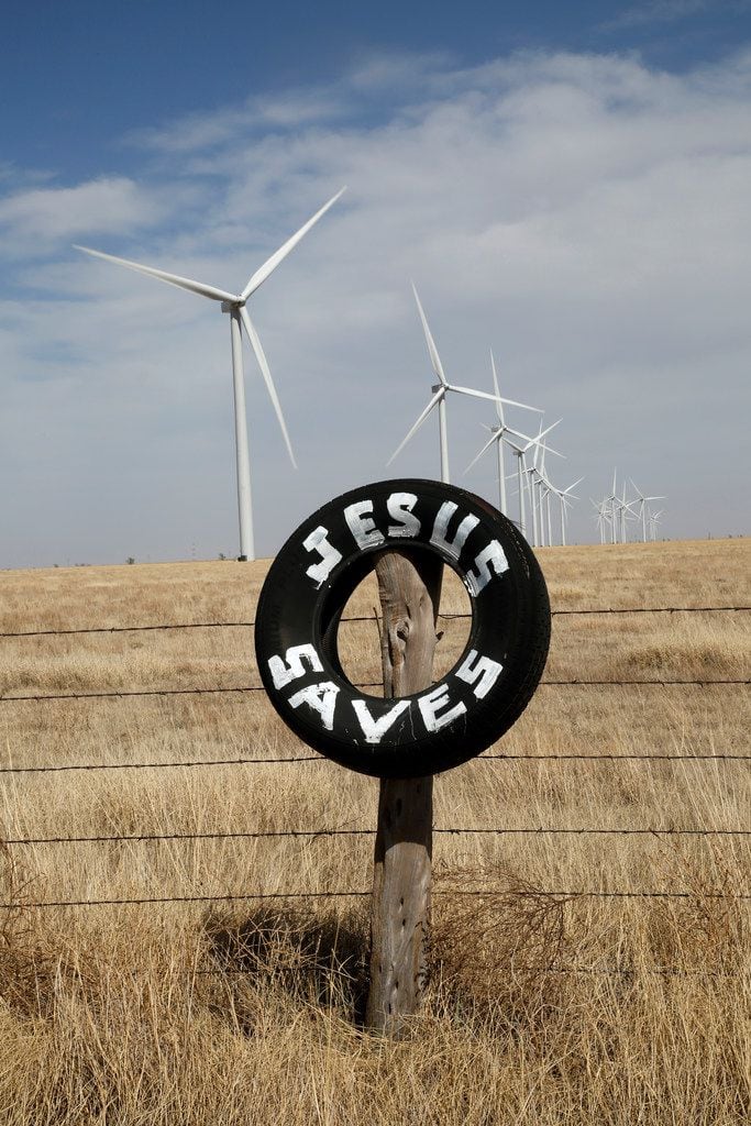 Wind turbines and a religious sign are seen on FM 168 near Happy, Texas, April 17, 2018. 