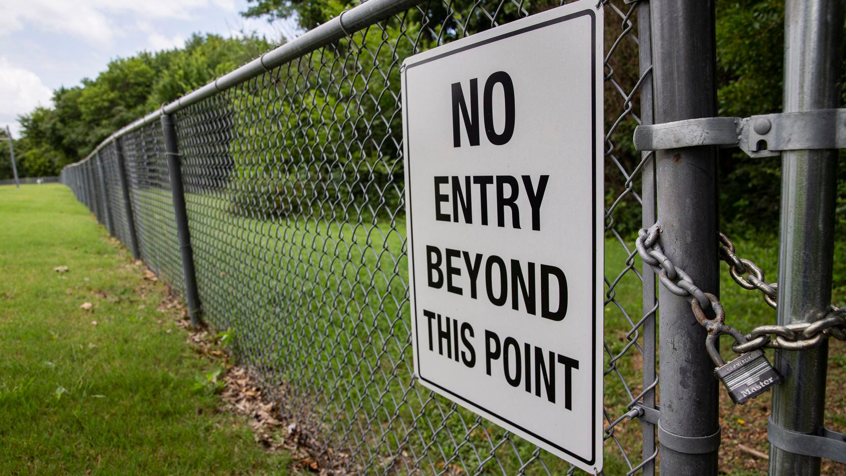 A sign at Parkcrest Elementary School on the fence separating the school from the creek on...