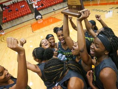 DeSoto's Ash'a Thompson (25) hoists the trophy after defeating South Grand Prairie 51-34 in the Class 6A Region I final last season. (Shaban Athuman/The Dallas Morning News)
