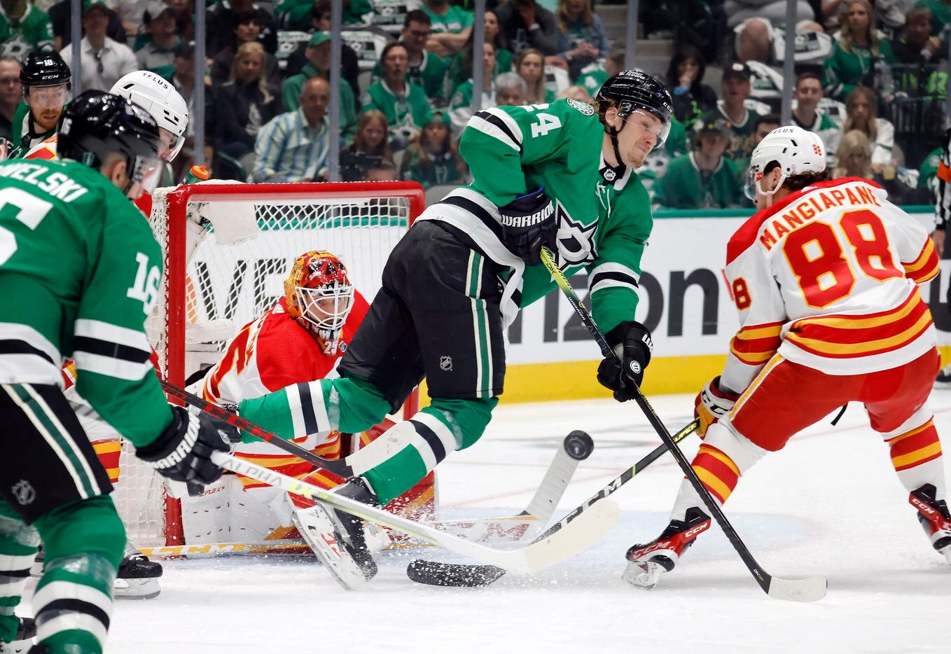 Dallas Stars center Roope Hintz (24) tries to stick the puck past Calgary Flames goaltender...