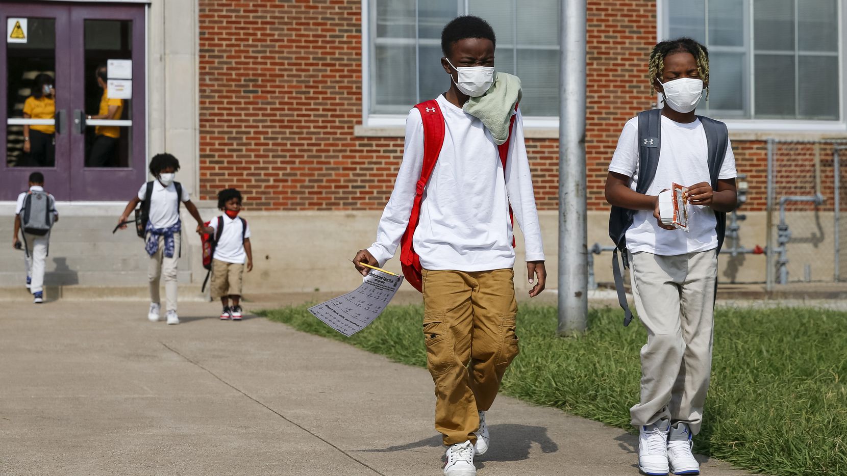 Jerrell Brown, 9 (left), walks with Jayce Williams, 7, after a day of classes at Paul L. Dunbar Learning Center on Wednesday, Sept. 8, 2021, in Dallas. (Elias Valverde II/The Dallas Morning News)