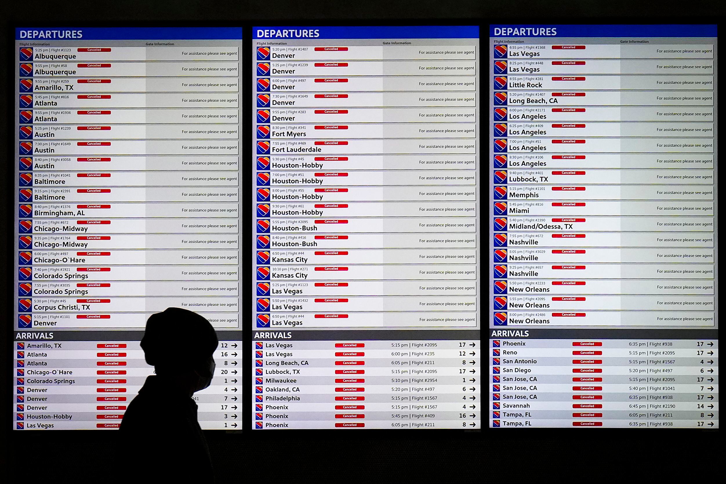 Flight status boards show all flights canceled for Southwest Airlines at Dallas Love field...