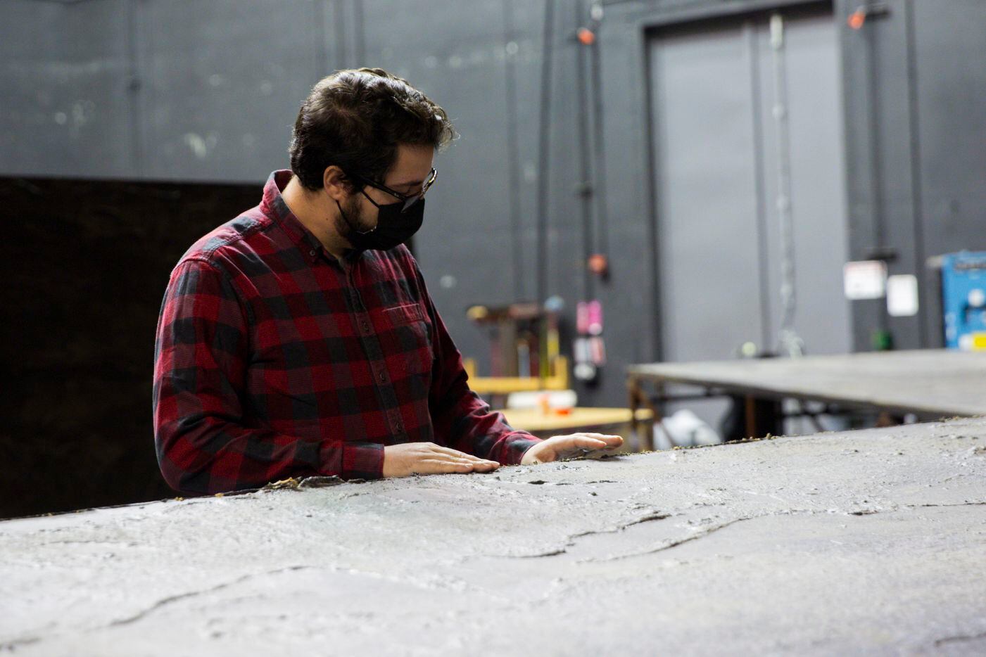 Atlanta Opera technical director Joshua Jansen checks the texture of a set piece made by...