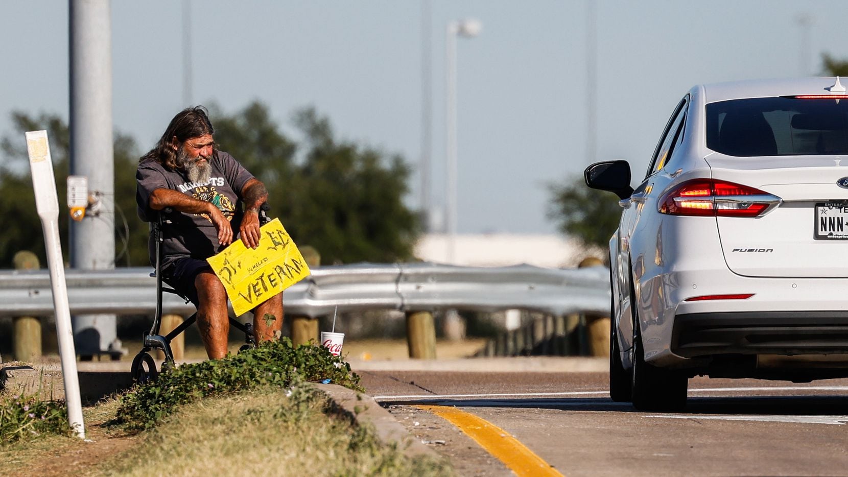 A panhandler on an I-30 exit ramp on Cockrell Hill Road in Dallas on Wednesday, Oct. 26, 2022.