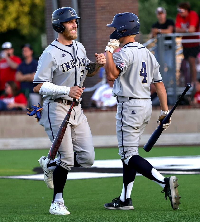 Keller outfielder Jacob Sullens (left) is greeted by Zach Makarawich (4) after scoring a run...
