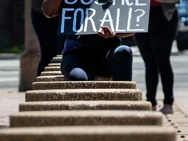 Shalini Maharaj joins protesters in a silent demonstration at Dallas City Hall to denounce...