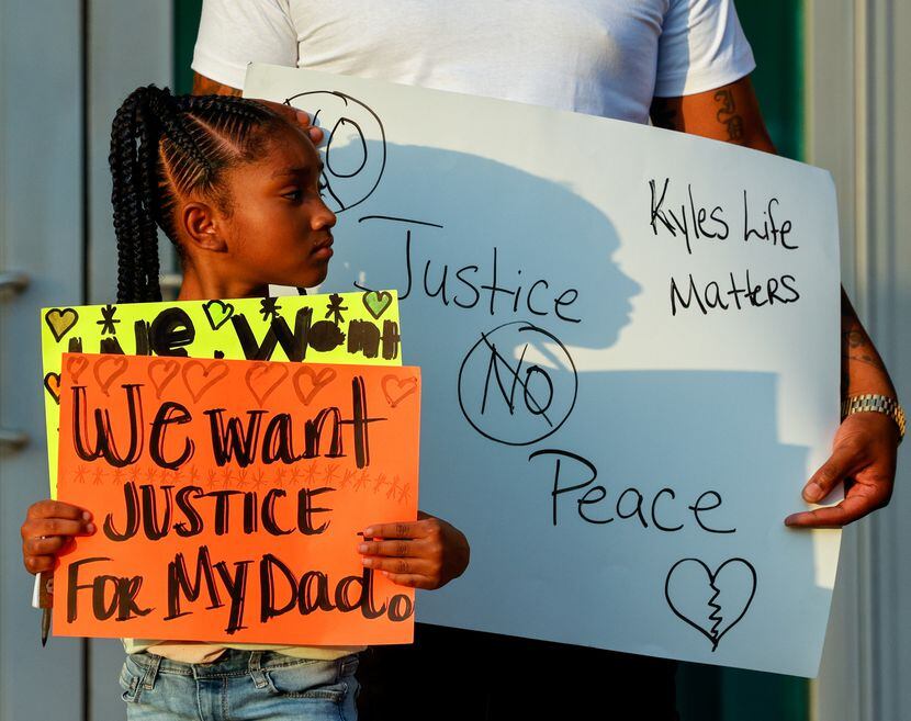 Kyle Dail’s daughter Kymari Dail, 7, holds a sign during a protest outside the Jack Evans...