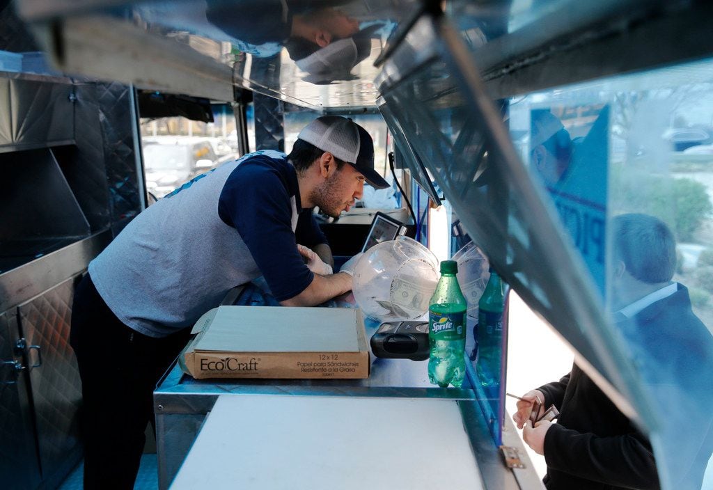 Cesar Villa of Frisco takes an order from a customer at Ruthie's Rolling Cafe food truck at...