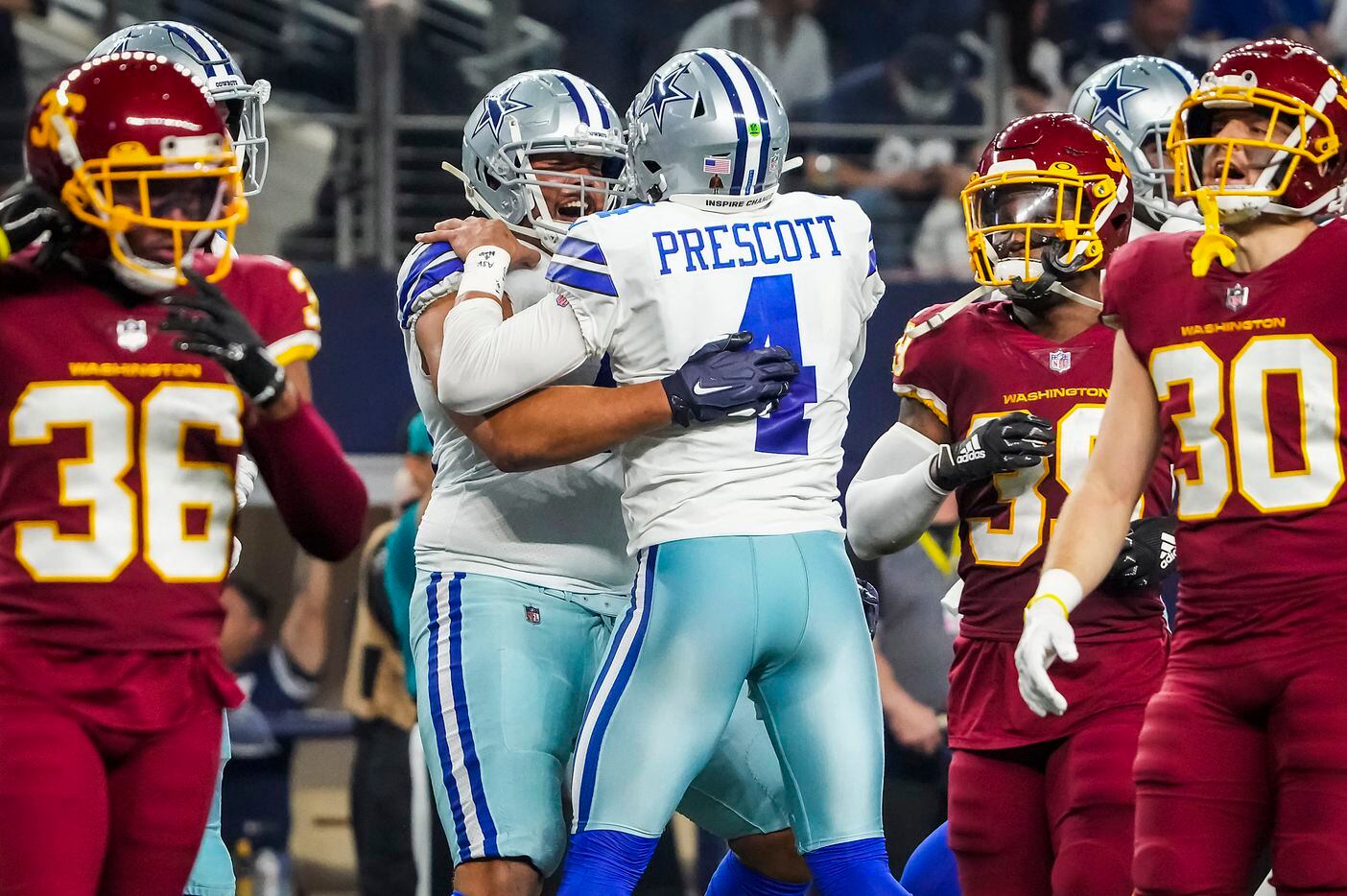Dallas Cowboys offensive tackle Terence Steele (78) celebrates with quarterback Dak Prescott (4) after scoring on a 1-yard touchdown reception during the first half of an NFL football game against the Washington Football Team at AT&T Stadium on Sunday, Dec. 26, 2021, in Arlington.