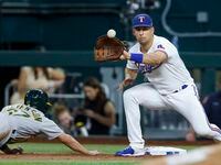 Texas Rangers first baseman Nathaniel Lowe (30) fields the ball as Oakland Athletics center...
