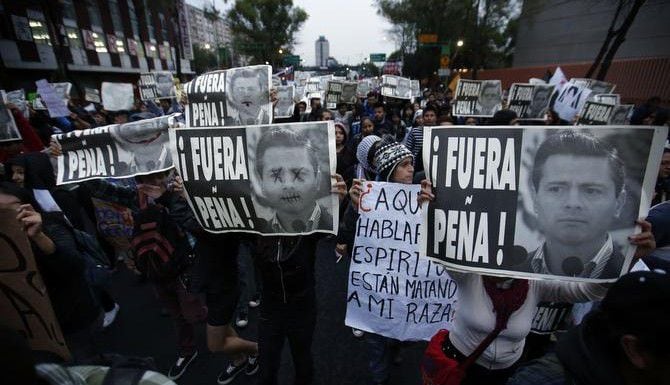 Manifestantes reclaman la renuncia del presidente Enrique Peña Nieto durante una marcha en...