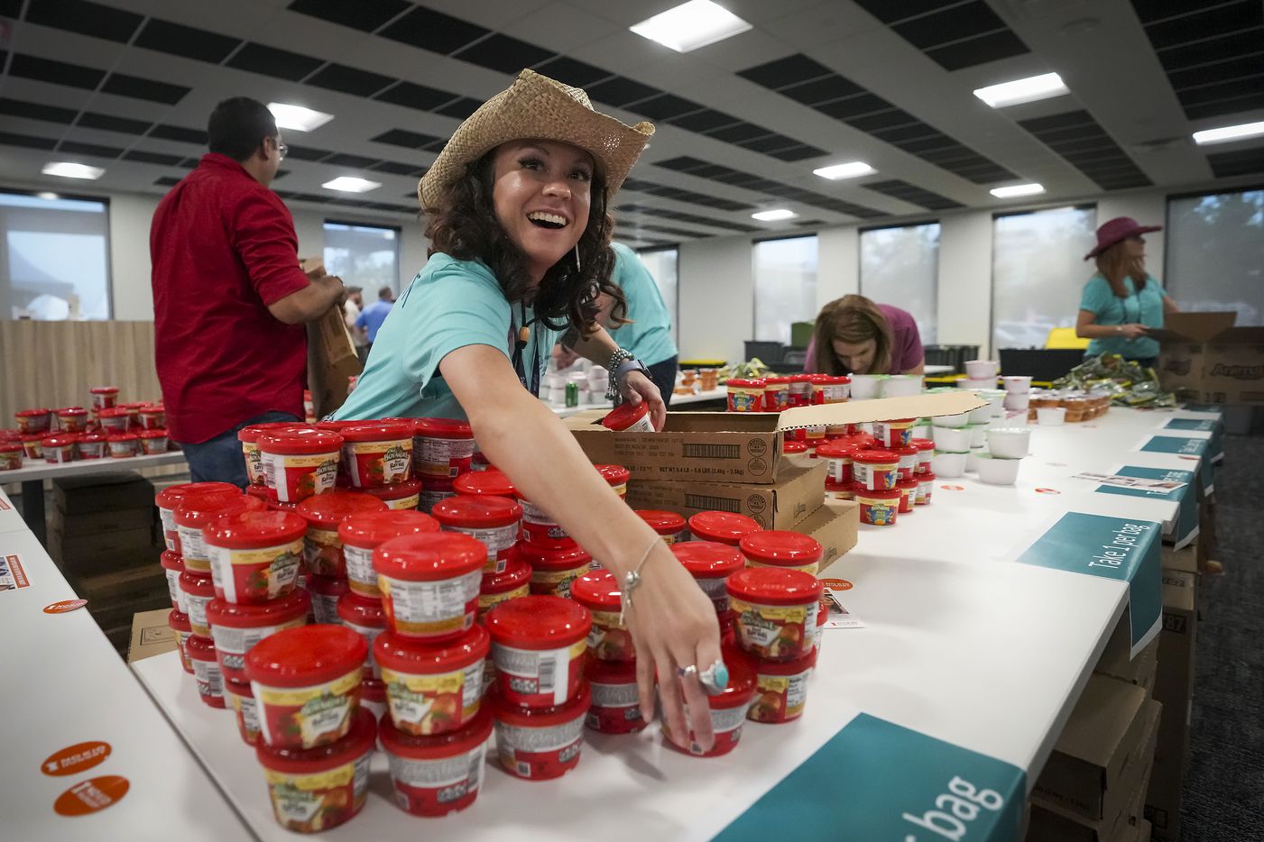 Alena Hogan, learning technology specialist set out food items to be sorted into donation...