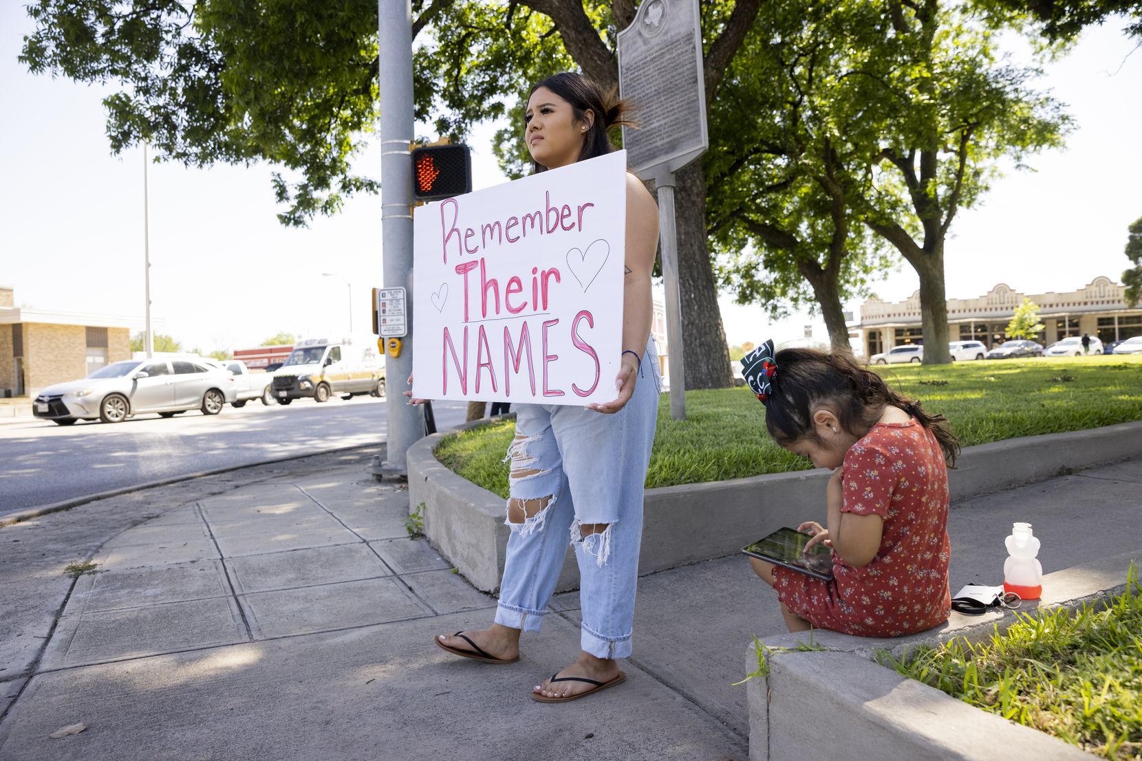 Martina Aguilar holds a sign to remember the children and two adults lost in the Robb...