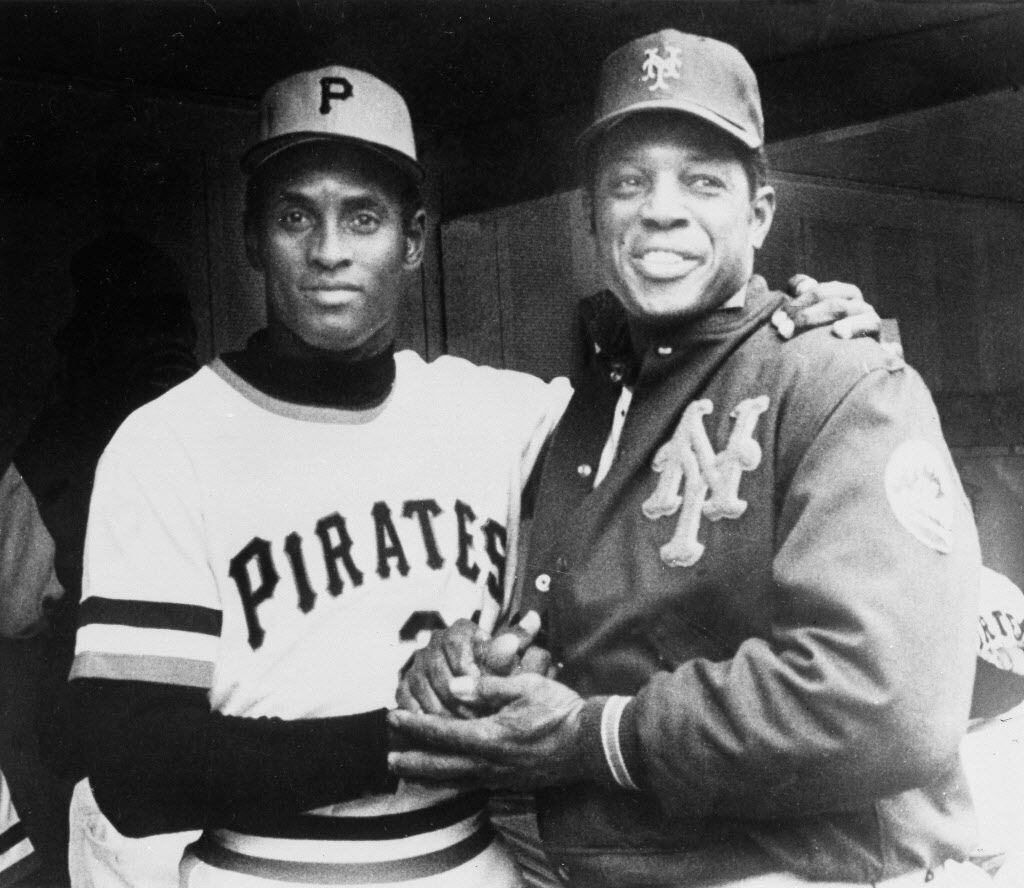 Pirates right fielder Roberto Clemente, left, gets a hand from Mets' Willie Mays after he...