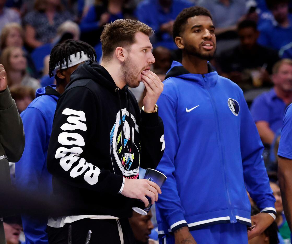 Dallas Mavericks guard Luka Doncic eats a snack on the sideline as he watches Game 1 of an...