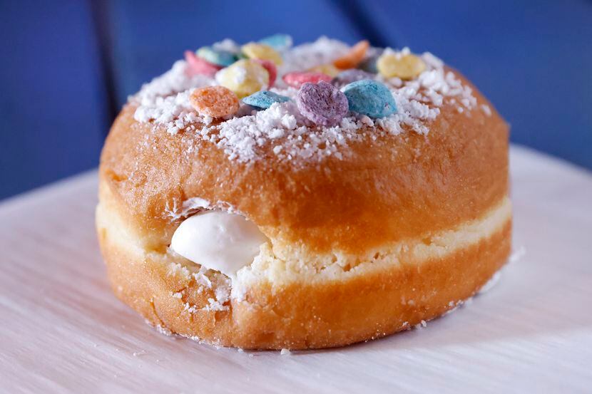 A cream-filled pastry is topped with powered sugar and Fruity Pebbles at The Spelled Milk, a...