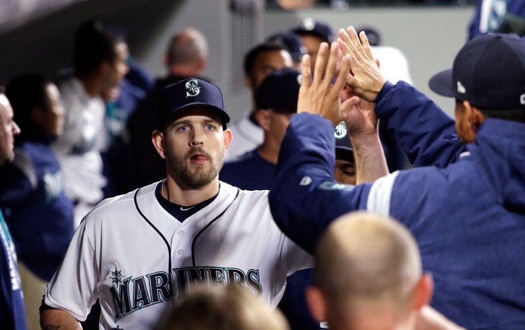 Seattle Mariners starting pitcher James Paxton is congratulated by teammates after coming...