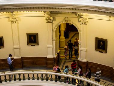 Chrisy Zartler (top right) walks around the third level of the rotunda at the Texas Capitol...