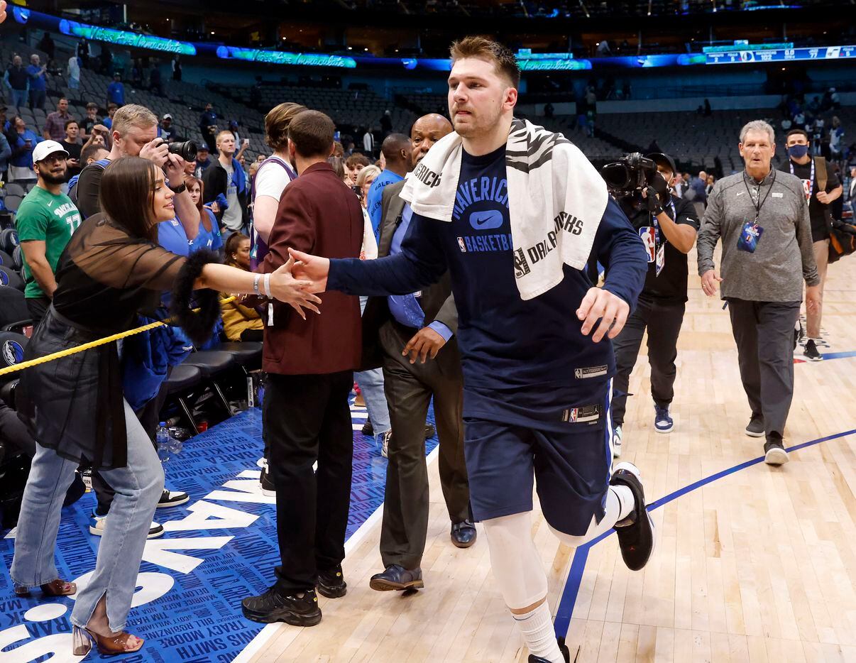 Dallas Mavericks guard Luka Doncic (77) slaps hands with fans after beating the Utah Jazz in...