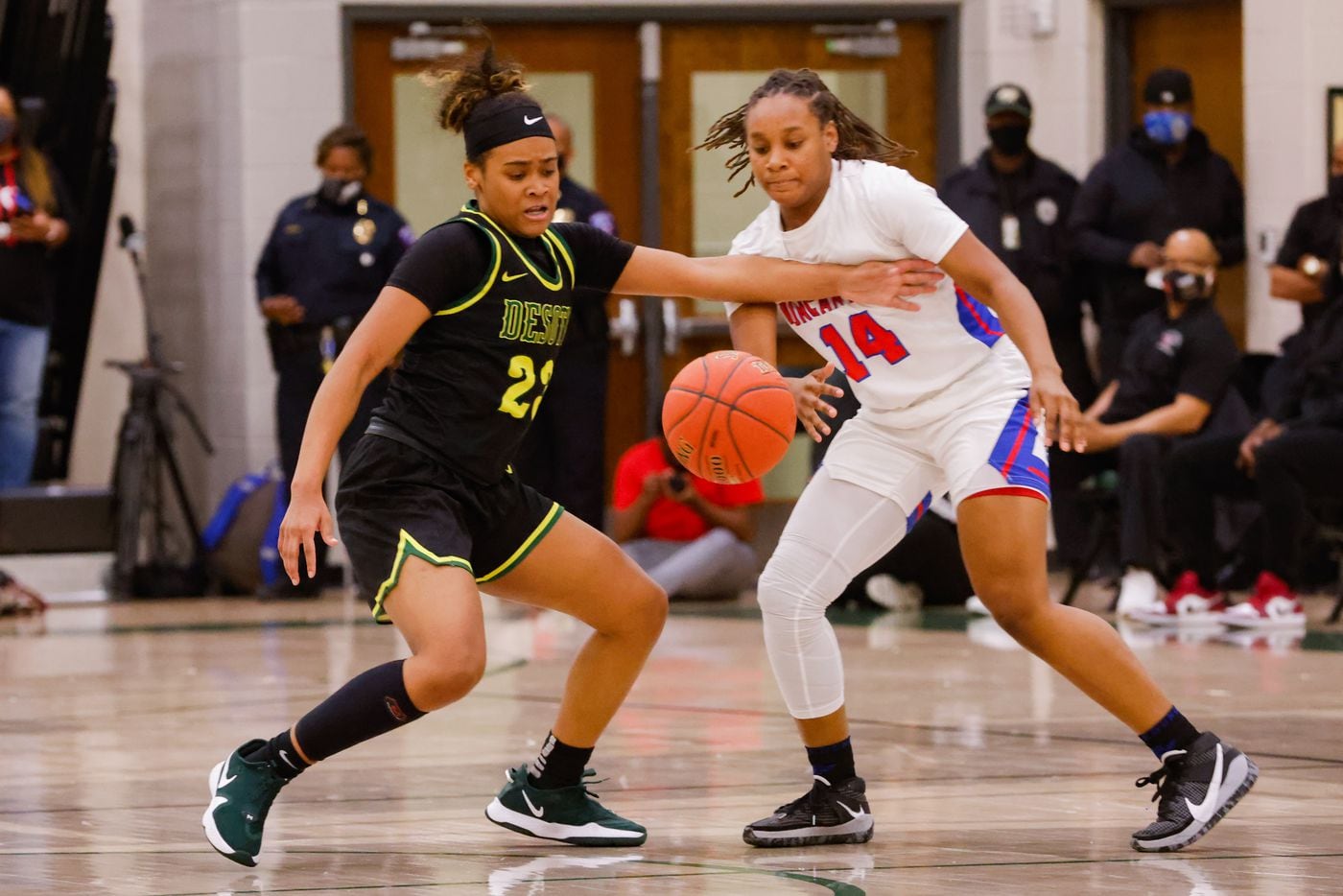 DeSoto's Kendall Brown (23) battles for the ball against Duncanville's Kaila Kerry (14)...