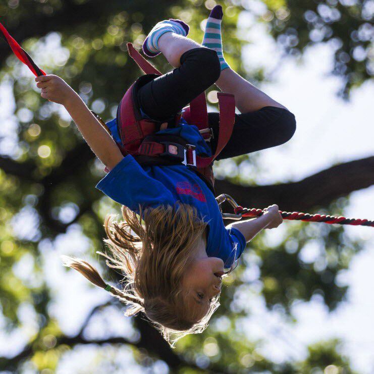 Evie Banis flips upside down on a jumping ride during Mayfest at Trinity Park in Fort Worth. 