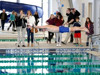 Former McKinney Mayor Brian Loughmiller took a ceremonial jump in the pool to swim a lap shortly after the ribbon cutting at the Apex Centre in this file photo from 2019. (Vernon Bryant/The Dallas Morning News)