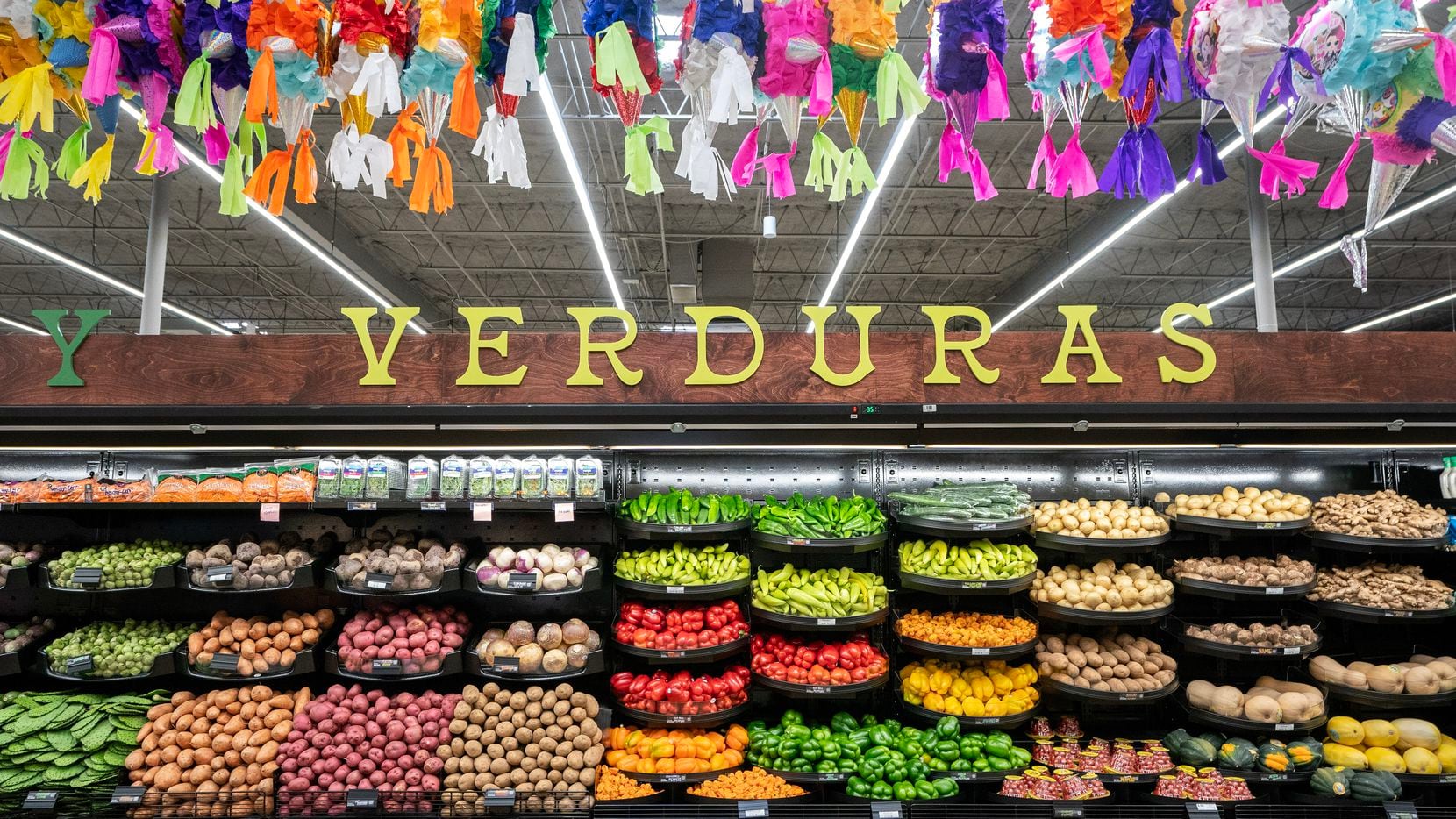 Piñatas hang above shelves stocked with vegetables in a new El Rio Grande Latin Market...
