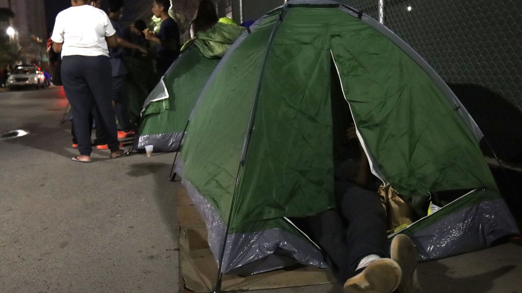 EL PASO— Migrants from Venezuela camp out in tents along the Greyhound bus station in...