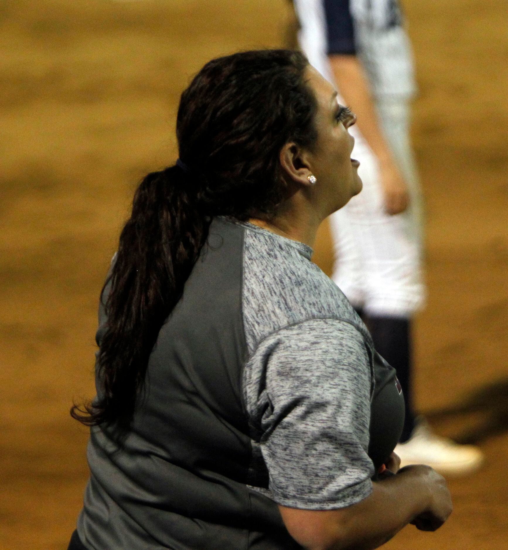 Plano head coach Brittany Welch coaches from outside the team dugout during the bottom of...