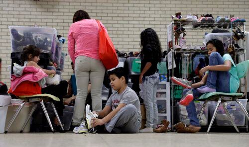 Migrantes buscan zapatos en un centro comunitario en McAllen.