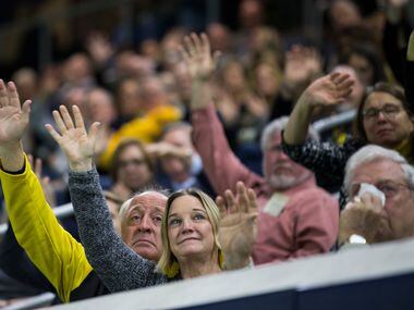 Friends, fans and former players wave goodbye to a photo of Hayden Fry, during a celebration...