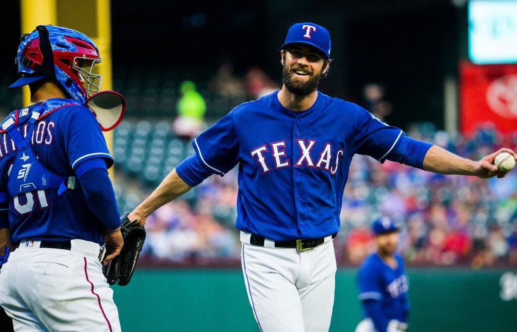 Texas Rangers starting pitcher Cole Hamels (35) and catcher Robinson Chirinos (61) wait for...