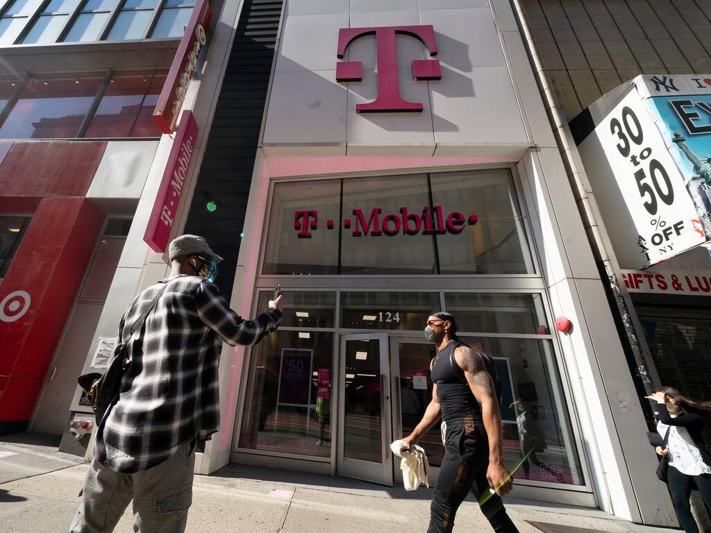 A man uses a mobile phone outside a T-Mobile store in April 2021 in New York.