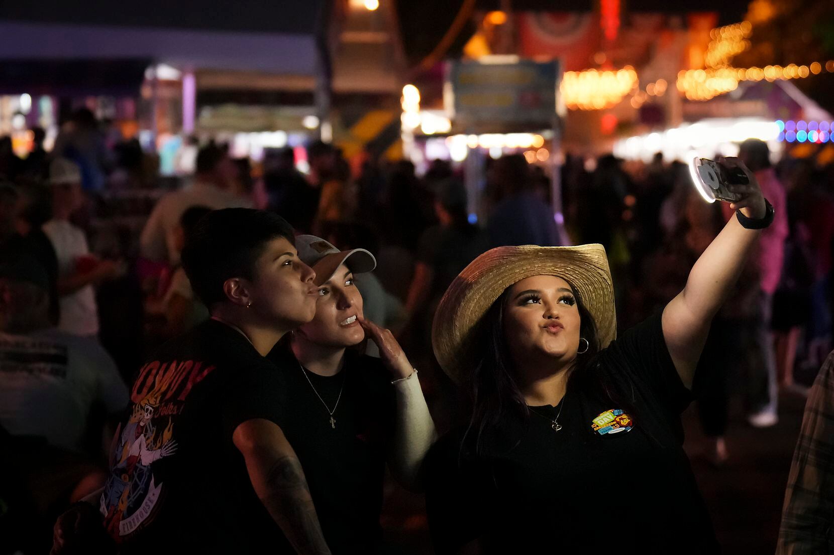 Fairgoers pause for a selfie near the Chevrolet Main Stage  on opening day at the State Fair...