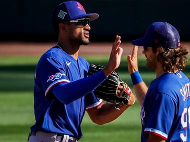 Texas Rangers outfielder Bubba Thompson celebrates with infielder Josh Smith after a victory...
