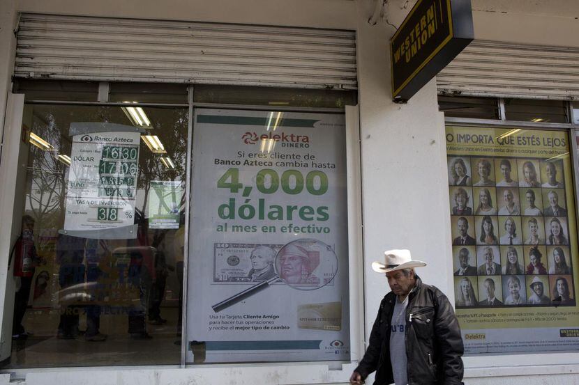 Un hombre pasa frente a un negocio de envío de dinero en la Ciudad de México. (AP/REBECCA...